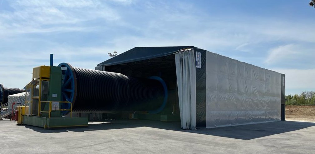 Bâtiment rétractable industriel à totalement replié pour stockage vrac avec accès latéral et structure mobile sur rails