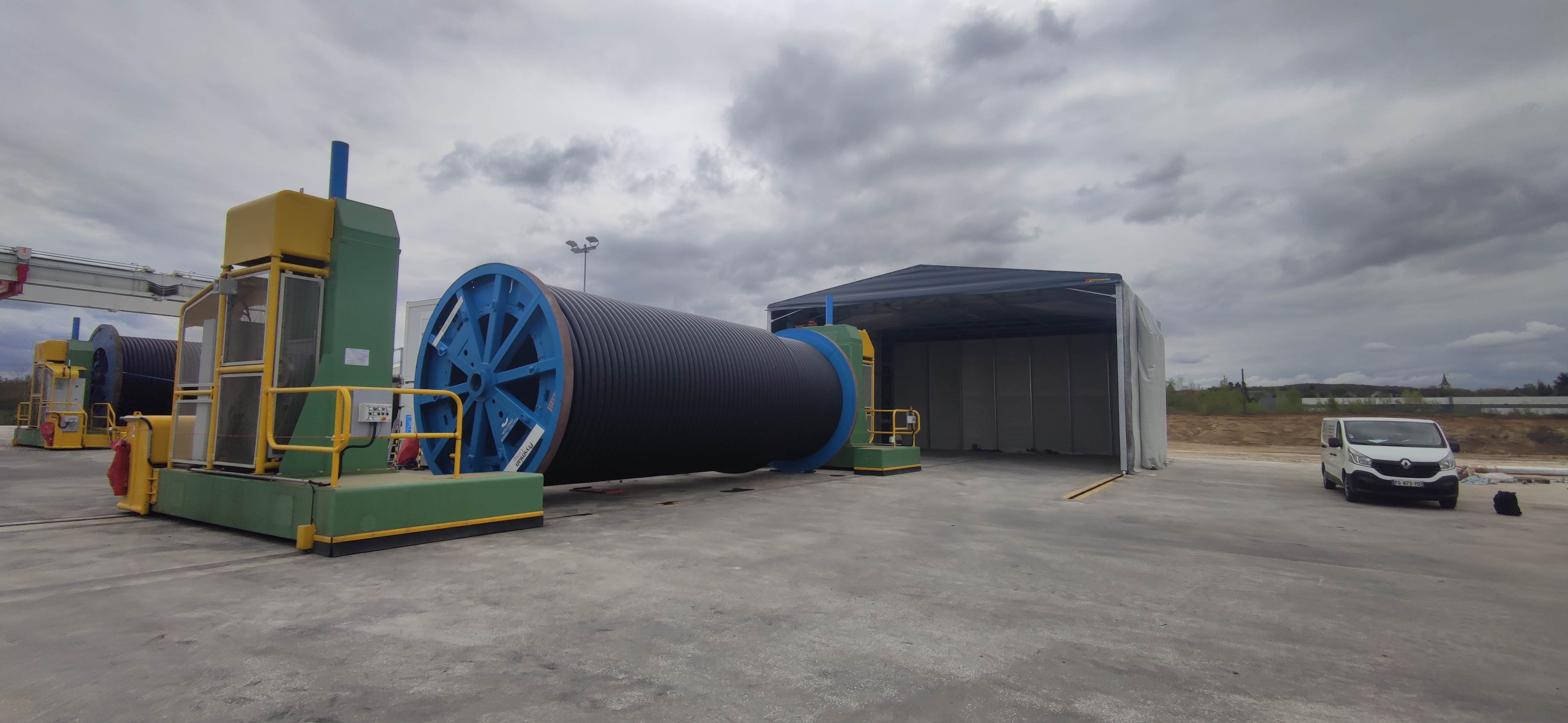 Bâtiment rétractable industriel replié pour stockage vrac avec accès latéral et structure mobile sur rails