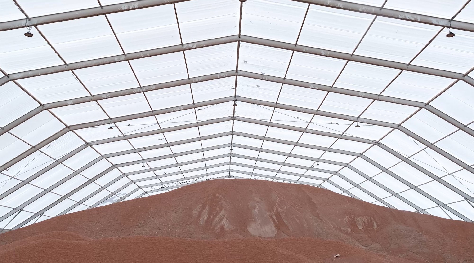 Bâtiment de stockage en vrac pour granulats ou sable avec grande portée en structure métallotextile sans poteaux