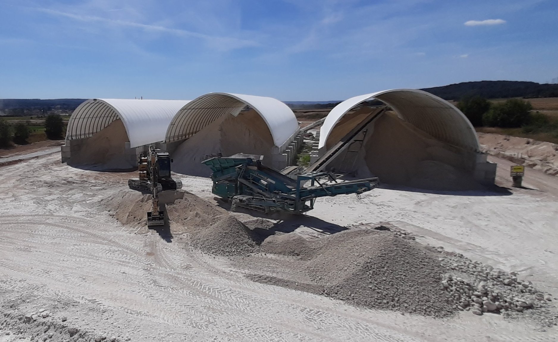 hangar dôme industriel pour stockage de matériaux en vrac avec murs en blocs béton LEGO résistance aux chocs engins chantier