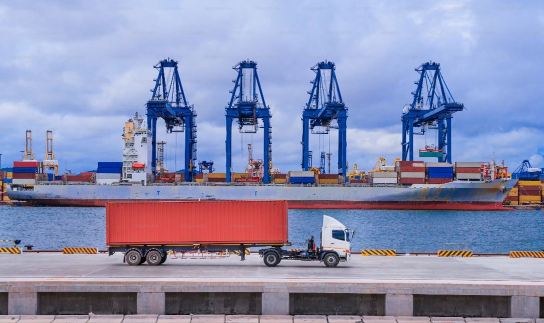 Plateforme logistique portuaire multimodale avec camion et navire, gestion des flux marchandises entre transport maritime et routier