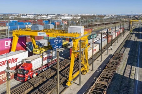 Terminal logistique multimodal rail-route avec portique de manutention conteneurs, plateforme optimisée pour transfert train camion et transport combiné