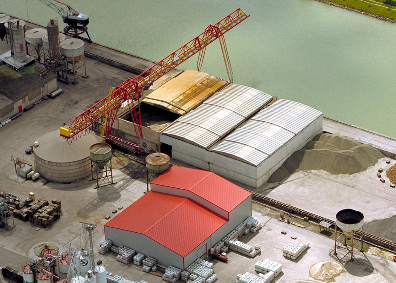 Bâtiment portuaire vrac avec toiture ouvrante permettant chargement et déchargement rapide par grappin en environnement maritime